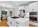 Bright kitchen features white cabinets, a stainless steel refrigerator, double ovens, and an island with a gas cooktop at 6409 Barkley Farm Rd, Huntersville, NC 28078