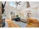 Inviting living room featuring hardwood floors, a large window, and an open layout to the dining area and kitchen at 6409 Barkley Farm Rd, Huntersville, NC 28078