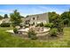 Stone patio with a seating area, fire pit, and lush landscaping for outdoor entertaining at 6409 Barkley Farm Rd, Huntersville, NC 28078