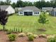 Expansive backyard featuring lush lawn, mature trees, and beautiful landscaping at 7057 Kingfisher Way, Belmont, NC 28012
