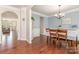 Elegant dining area with hardwood flooring, wainscoting, and a view into the adjacent living room at 8829 Keller Ct, Huntersville, NC 28078