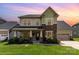 Charming two-story home with a combination of siding and stone exterior, lush lawn, and inviting front porch at 8829 Keller Ct, Huntersville, NC 28078
