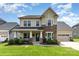 Charming two-story home with stone accents, a covered front porch, and well-manicured landscaping at 8829 Keller Ct, Huntersville, NC 28078