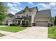Inviting two-story home featuring stone accents, a well-manicured lawn, and an attached two-car garage at 8829 Keller Ct, Huntersville, NC 28078