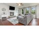 Cozy living room featuring a stone fireplace, plush seating, and large windows overlooking the backyard at 8829 Keller Ct, Huntersville, NC 28078