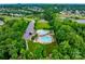 Aerial view of community pool, clubhouse, tennis courts, green space surrounded by mature trees at 8830 Artesa Mill Ln, Charlotte, NC 28214