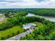 Aerial view of community pool, clubhouse, lake and a playground surrounded by mature trees at 8830 Artesa Mill Ln, Charlotte, NC 28214