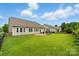 Well-maintained backyard showcasing a patio, playset, mature trees, and ample green space for outdoor activities at 8830 Artesa Mill Ln, Charlotte, NC 28214