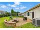 Lush backyard with a stone patio, fire pit, seating area, and a playset, perfect for outdoor enjoyment at 8830 Artesa Mill Ln, Charlotte, NC 28214