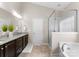Bathroom with granite double vanity, soaking tub, and glass shower at 8830 Artesa Mill Ln, Charlotte, NC 28214