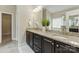 Bathroom featuring dual sinks, granite countertops, dark wood cabinets, and a view of a walk-in closet at 8830 Artesa Mill Ln, Charlotte, NC 28214