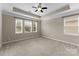 Spacious bedroom featuring a tray ceiling, plush carpeting, and large windows at 8830 Artesa Mill Ln, Charlotte, NC 28214