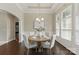 Elegant dining room with a round table set for four, complemented by wainscoting and a chandelier, bathed in light at 8830 Artesa Mill Ln, Charlotte, NC 28214