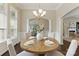 Formal dining area featuring a wooden table, wainscoting, and a chandelier, offering a view into adjacent living spaces at 8830 Artesa Mill Ln, Charlotte, NC 28214