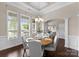 Sunlit dining room featuring hardwood floors, white trim, and large windows with blinds at 8830 Artesa Mill Ln, Charlotte, NC 28214