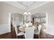 Elegant dining room with a chandelier, views into the living room, and neutral walls at 8830 Artesa Mill Ln, Charlotte, NC 28214