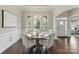 Bright dining room featuring elegant wainscoting, a chandelier, and a table set for four with natural light at 8830 Artesa Mill Ln, Charlotte, NC 28214