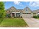 Charming home with a stone facade, well-manicured lawn, and a two-car garage, set beneath a beautiful sky at 8830 Artesa Mill Ln, Charlotte, NC 28214