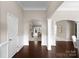 Inviting foyer with dark wood floors, elegant arches, and views into the living spaces at 8830 Artesa Mill Ln, Charlotte, NC 28214