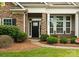 Charming home featuring a stone facade, black front door, and well-manicured landscaping at 8830 Artesa Mill Ln, Charlotte, NC 28214