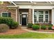 Lovely front entrance features stone accents and lush greenery, creating a welcoming ambiance at 8830 Artesa Mill Ln, Charlotte, NC 28214