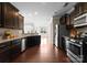 Open concept kitchen with stainless appliances, wood flooring, and dark wood cabinets at 8830 Artesa Mill Ln, Charlotte, NC 28214