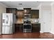 Bright kitchen featuring stainless steel appliances, dark cabinets, and wood flooring at 8830 Artesa Mill Ln, Charlotte, NC 28214