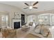 Bright living room featuring a fireplace, ceiling fan, and large windows with a cozy atmosphere at 8830 Artesa Mill Ln, Charlotte, NC 28214