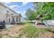 Enjoyable backyard features a playground, a covered patio with chairs, and grill at 8927 Comstock Ct, Locust, NC 28097