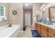 Bathroom with a soaking tub, tiled floors, and a double vanity at 8927 Comstock Ct, Locust, NC 28097