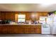 Kitchen featuring wood cabinets, white appliances, and laminate flooring at 100 Lanier St, Mount Holly, NC 28120