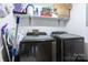Laundry room with black stainless steel washer and dryer set and white shelving at 100 Lanier St, Mount Holly, NC 28120