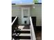 Back entrance featuring a wooden staircase with handrails, pet door access, and covered awning at 102 Papoose Ct # D117, Mount Gilead, NC 27306