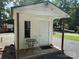 Exterior of the shed with a small porch featuring a table and chairs, adjacent to a gravel yard at 102 Papoose Ct # D117, Mount Gilead, NC 27306