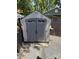 A gray Craftsman storage shed with a door and trim of similar colors, with an adjacent wood fence at 102 Papoose Ct # D117, Mount Gilead, NC 27306