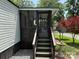 Home featuring a screened porch with access stairs and a bird bath in a well-maintained yard at 102 Papoose Ct # D117, Mount Gilead, NC 27306