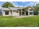 Exterior rear of the home with a large lawn, modern architecture, and a covered patio at 1207 Lakedell Dr, Charlotte, NC 28215