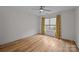 Sunlit bedroom with hardwood floors, ceiling fan, and decorative curtains framing the large window at 1207 Lakedell Dr, Charlotte, NC 28215