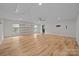 Large bonus room with hardwood floors, ceiling fan, modern shelving, and natural light at 1207 Lakedell Dr, Charlotte, NC 28215
