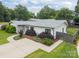Well-manicured lawn and landscaping surround the home showcasing its gray shingle roof and white siding at 1207 Lakedell Dr, Charlotte, NC 28215