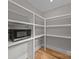 Walk-in pantry featuring laminate floors, built-in white shelving, and ample storage space at 1207 Lakedell Dr, Charlotte, NC 28215