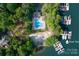 Aerial shot featuring a community pool, boat slips, and sandy beach, surrounded by lush greenery and water at 122 Waterford Dr, Mooresville, NC 28117