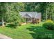 A picturesque exterior featuring a classic brick home with lush green surroundings and mature trees at 122 Waterford Dr, Mooresville, NC 28117
