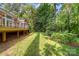 Spacious backyard with a wooden deck and lush green lawn surrounded by mature trees offering privacy at 122 Waterford Dr, Mooresville, NC 28117