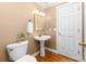 Bright bathroom with a pedestal sink, framed mirror, and wood floors at 122 Waterford Dr, Mooresville, NC 28117