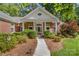 Inviting entrance to brick home with manicured landscaping leading to a charming front porch with rocking chairs at 122 Waterford Dr, Mooresville, NC 28117