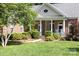 Charming brick home featuring a covered front porch with classic columns and beautifully manicured landscaping at 122 Waterford Dr, Mooresville, NC 28117