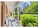 Covered front porch with rocking chairs and elegant white columns offers a serene view of the lush green lawn at 122 Waterford Dr, Mooresville, NC 28117
