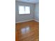 Cozy bedroom features hardwood floors and a large window for natural light at 1245 Paddock Cir, Charlotte, NC 28209