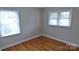Bedroom with gleaming hardwood floors and natural light pouring through the windows at 1245 Paddock Cir, Charlotte, NC 28209